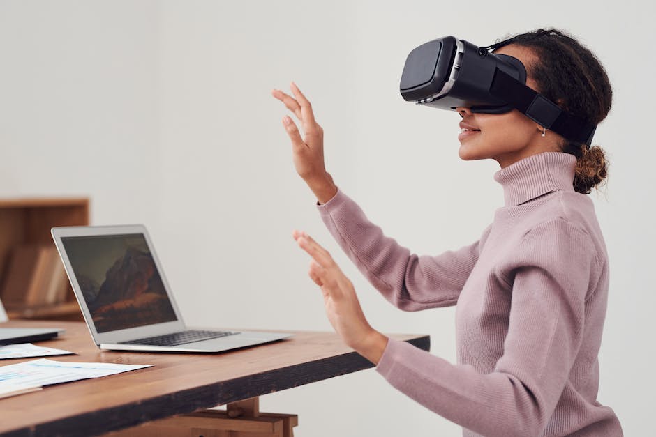 A person wearing a VR headset with a look of calm and relaxation on their face as they are immersed in a virtual beach environment with waves gently crashing on the shore.