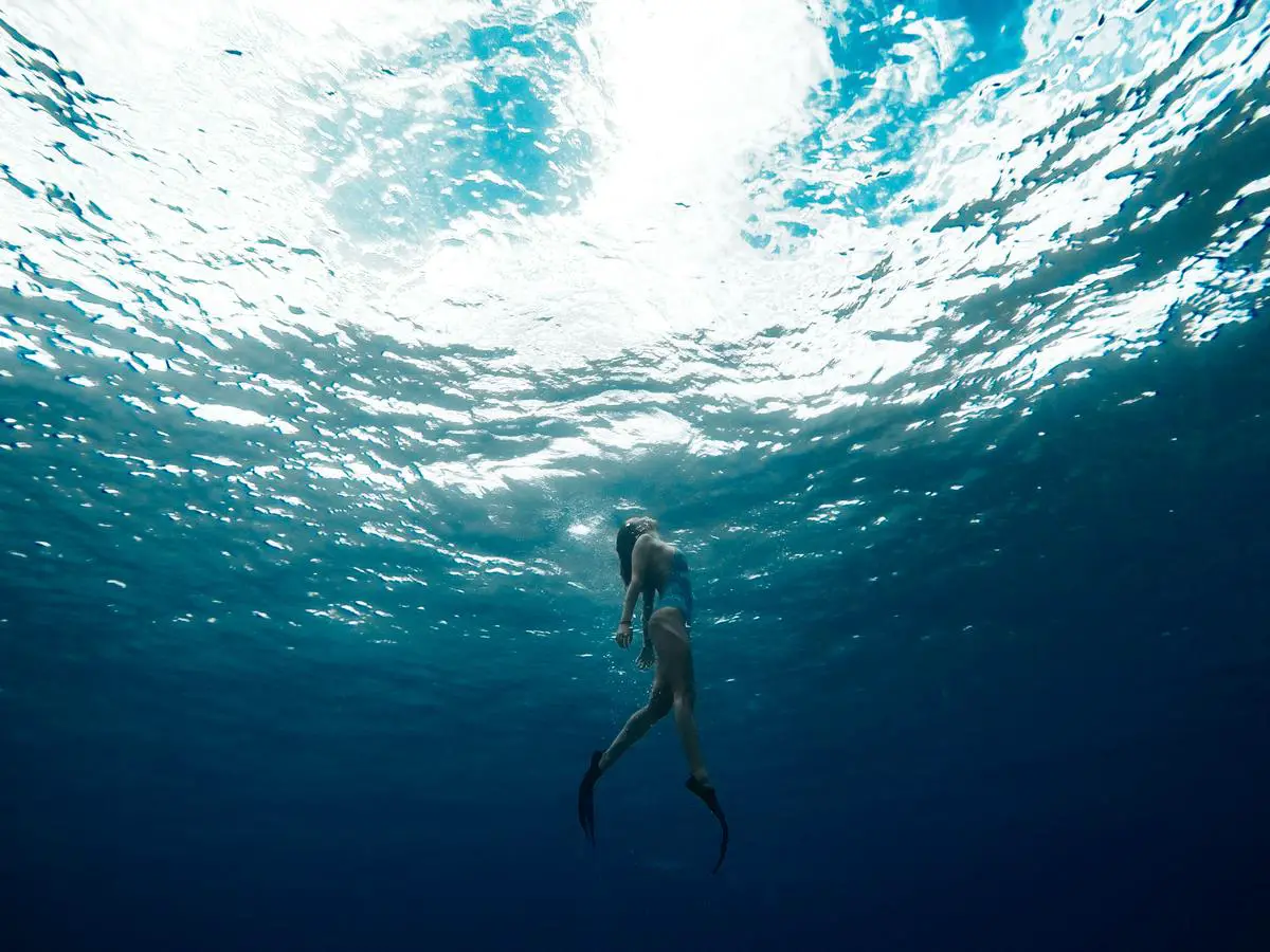 Illustration of a person swimming underwater, highlighting the sense of calm and peace that can occur in underwater dreams.